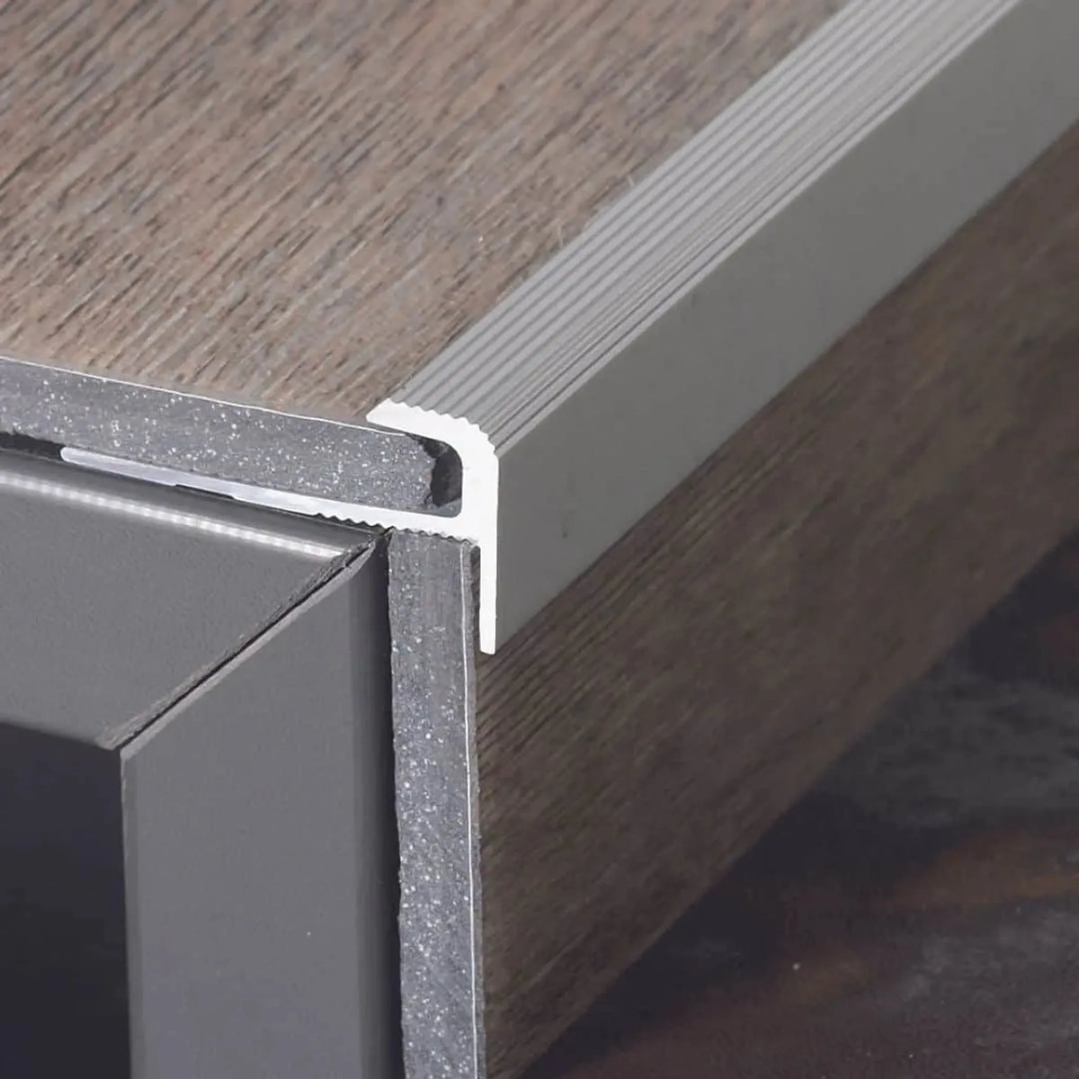 Stair edge profile F-shape aluminium installed on step with vertical and horizontal inserted vinyl floor