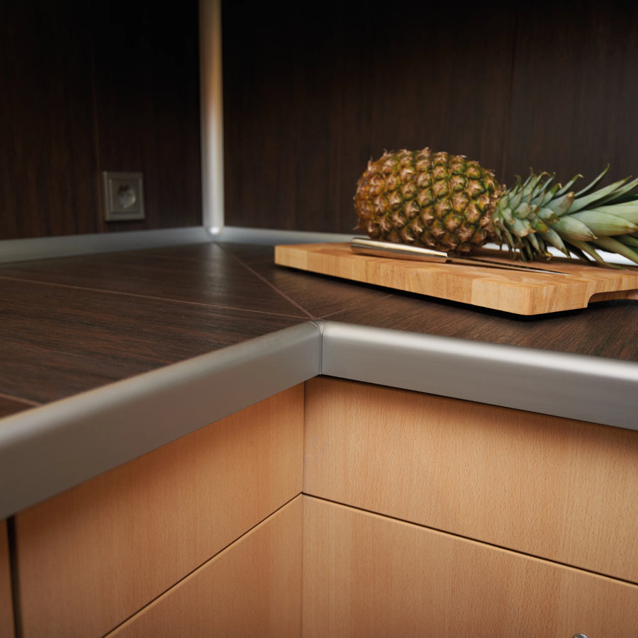 Ambientebild Arbeitsplattenprofil an einer Arbeitsplatte installiert auf der ein Brett mit einer Ananas liegt #A0002397