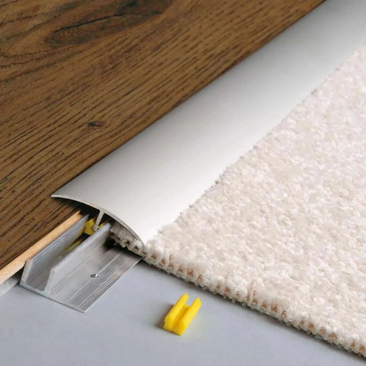 profilé de compensation de hauteur anodisé argenté CLIP. Plancher en bois inséré brun d'un côté et moquette claire de l'autre. #FR0003681
#FR0003682