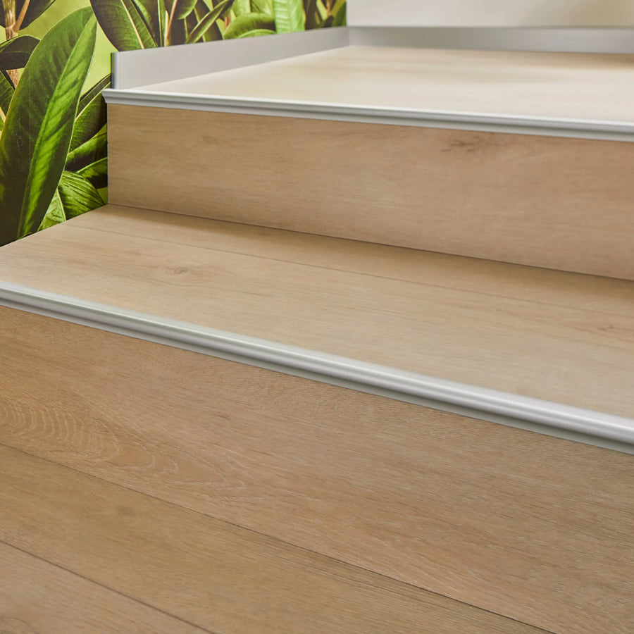 Ambientebild Treppenstufen-Einschubprofil Aluminium silber matt eloxiert mit hellem Laminat verarbeitet auf mehreren Stufen