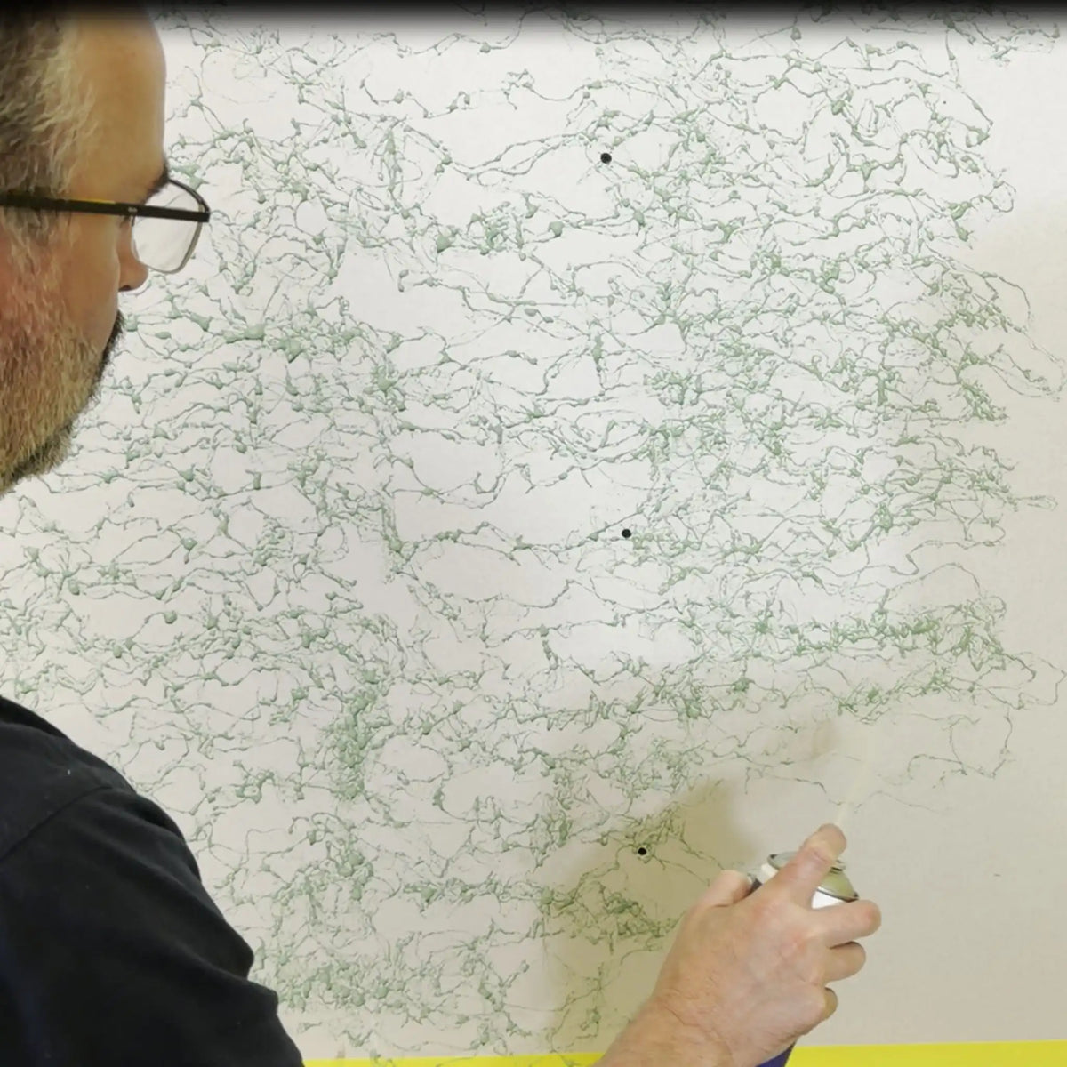 Ambientebild Spruehprimer der ein Design an eine Wand sprüht 