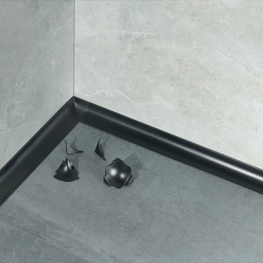 Ambientebild schwarzes Wandanschlussprofil mit Eckstücken zwischen Boden und Wand installiert ##A0005063