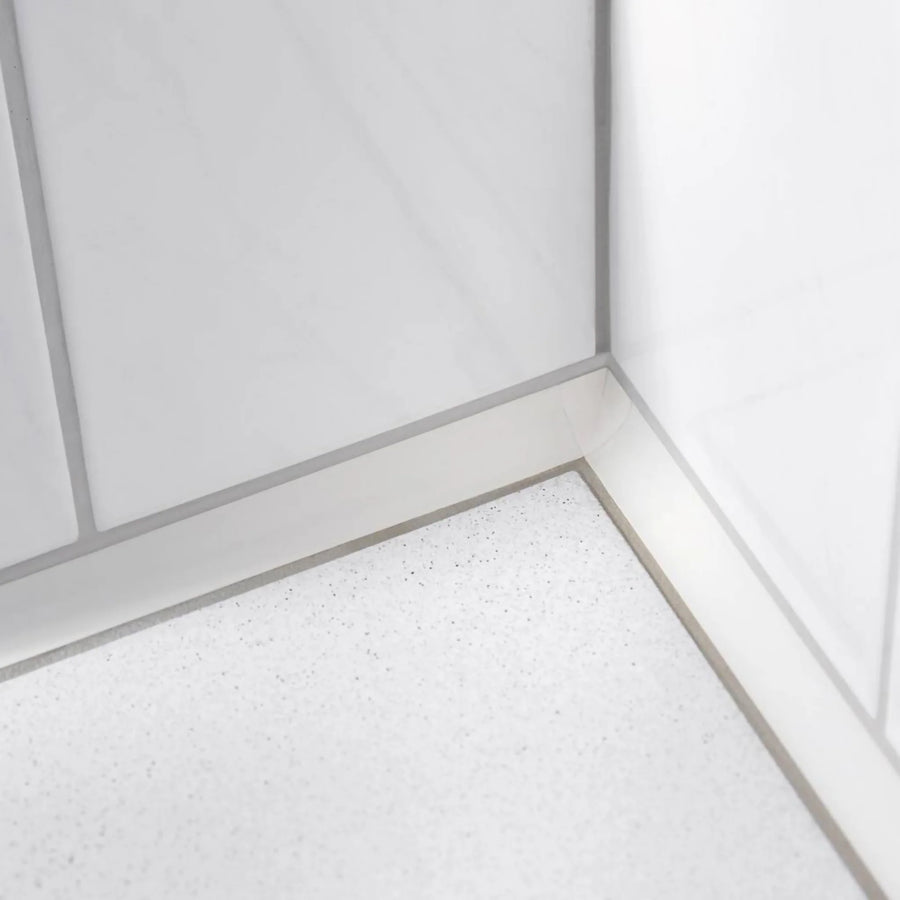 Ambientebild weisses Wandanschlussprofil zwischen weissen Wand- und Bodenfliesen #A0002912