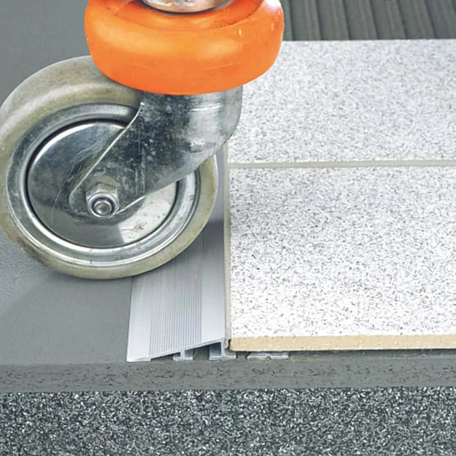 Höhenausgleichsprofil aus Aluminium mit geriffelter Rampe unter einer Fliese verarbeitet.