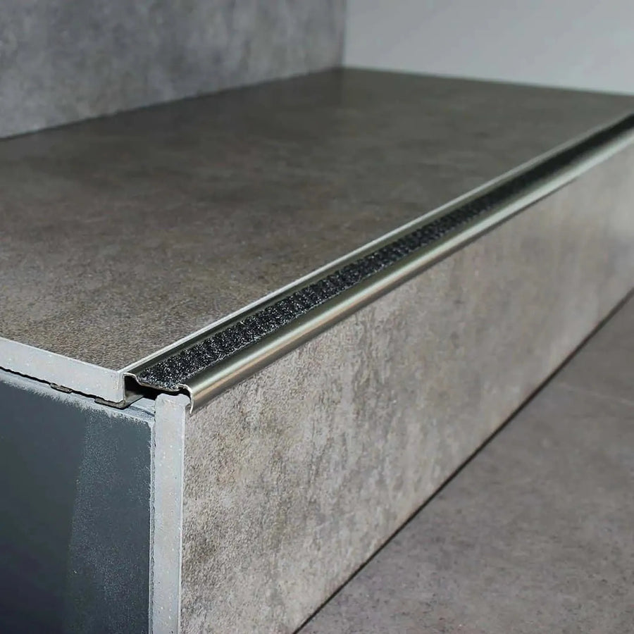 Verbautes Treppenkantenprofil Aluminium rutschhemmend mit nachtscwarzer Einlage an Stufe mit grauen Fliesen #A0001724
#A0002701

