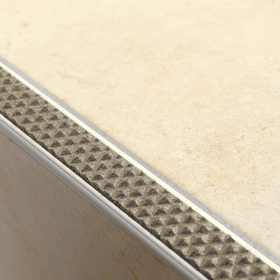 Verbautes Treppenkantenprofil Aluminium rutschhemmend mit sandfarbener Einlage an Stufe mit hellen Fliesen #farbe_sand
