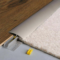 Installed titanium anodised height adjustment profile CLIP. Brown inserted wood floor on one side and light carpet floor on the other side #A0003687 #A0003688