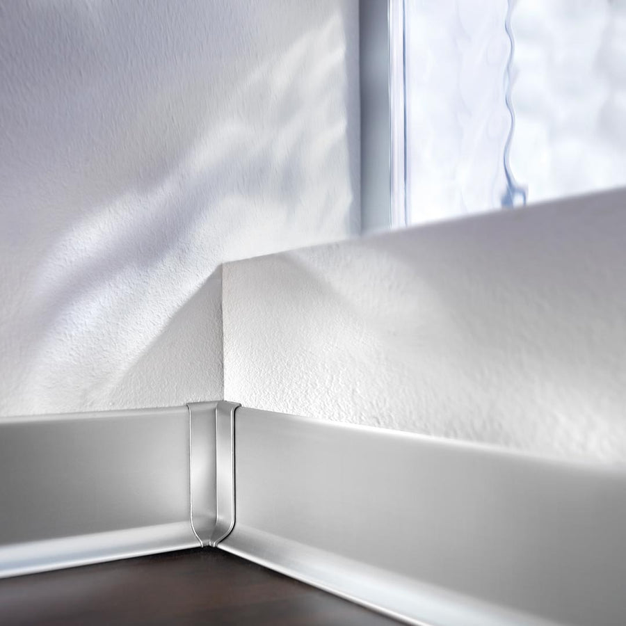 An einer Wand verbaute Sockelleiste mit Fokus auf die silberne Innenecke Sockelleiste Aluminium #farbe_silber