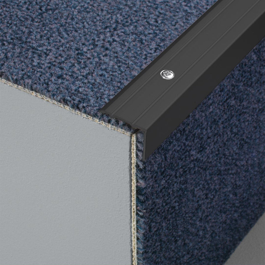 Gebohrtes Stufenprofil aus Aluminium schwarz matt in L-Form und geriffelter Oberfläche auf einer Treppe mit Teppich #A0005114 #A0005117