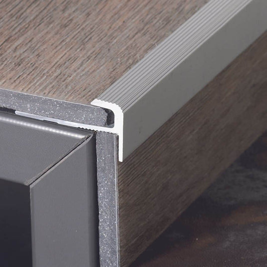 An Stufe verbautes Treppenkantenprofil F-Form Aluminium mit senkrecht und waagerechte eingeschobenen Vinylboden